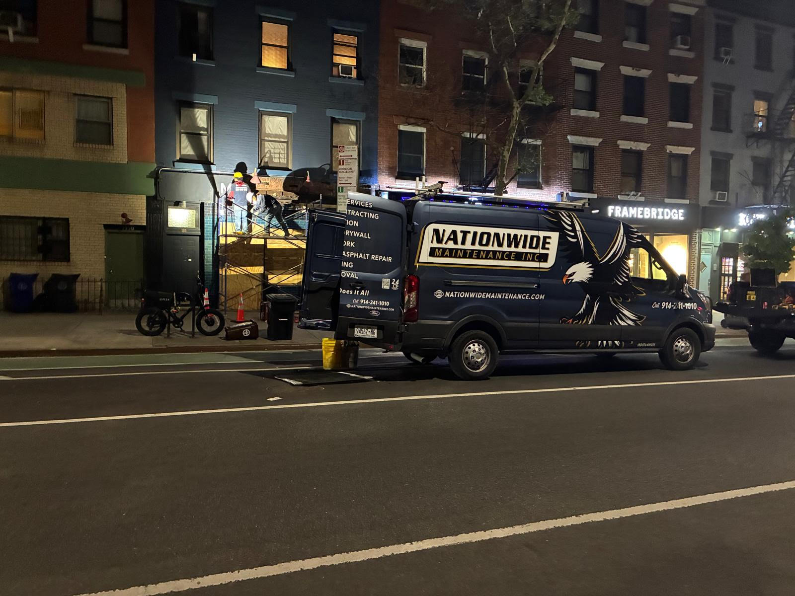 Nationwide Maintenance van and crew working on a Manhattan storefront at night