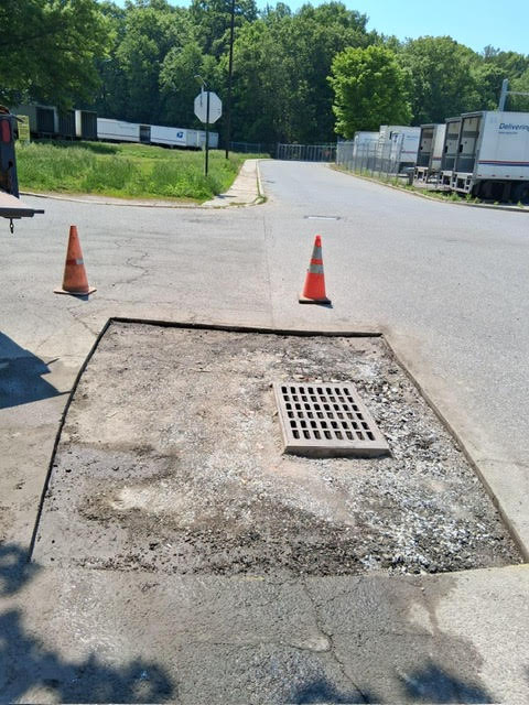 Broken storm drain and asphalt before repair