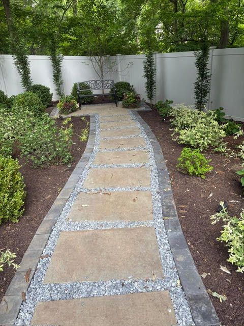 Stone slab walkway through landscaped backyard garden