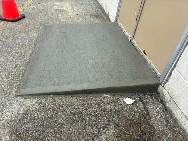 Fresh concrete access ramp outside a service door