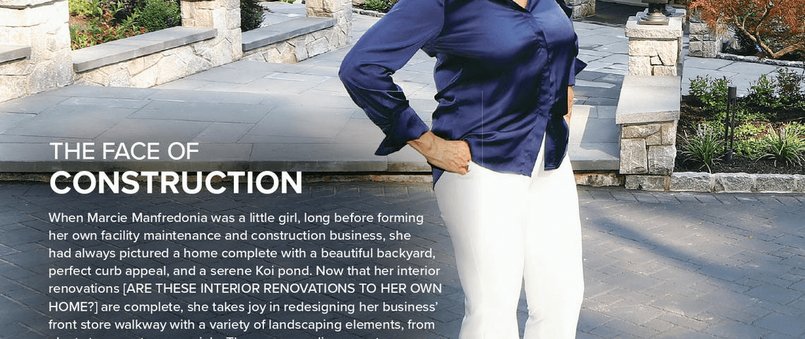 A woman in a navy blouse and white pants stands smiling on a paved walkway in front of a landscaped home, with text describing her construction business and contact information at the bottom.