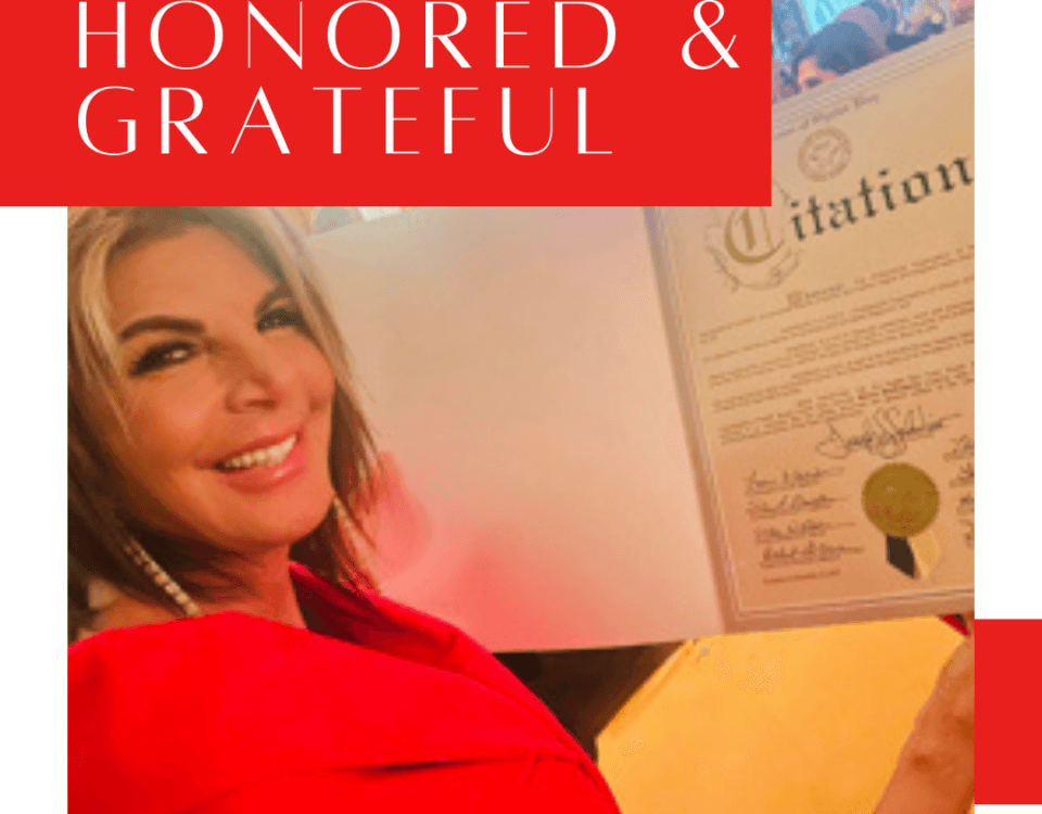 A woman in a red outfit smiles while holding a framed certificate. Text on the image reads “What a Beautiful Surprise: Honored & Grateful.” Blog and Instagram links appear at the bottom.