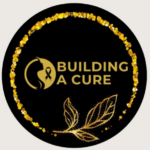 A black circular logo with a gold glitter border, featuring a silhouette of a womans head with a gold ribbon. The text BUILDING A CURE is in gold, with two gold leaves at the bottom.